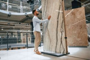 Hombre inspeccionando una gran placa de mármol pulido en un showroom moderno